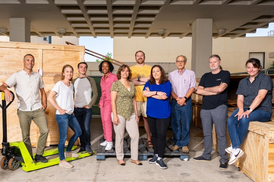 The ExFAB group standing together in a warehouse